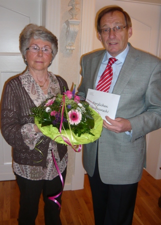 Der Stadtverbandsvorsitzende Lothar Gohmann gratuliert Frau Marianne Kraul mit einem Blumenstrauß